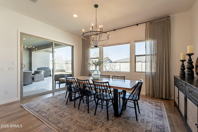 dining room with baseboards, wood finished floors, and a notable chandelier