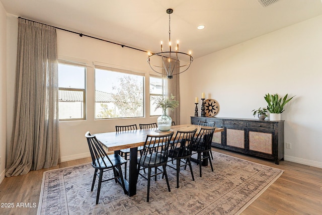 dining space with a chandelier, recessed lighting, baseboards, and wood finished floors