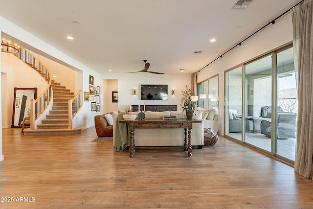 living area with visible vents, light wood-style flooring, ceiling fan, stairs, and recessed lighting