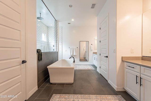 bathroom with recessed lighting, visible vents, a freestanding bath, a tile shower, and vanity