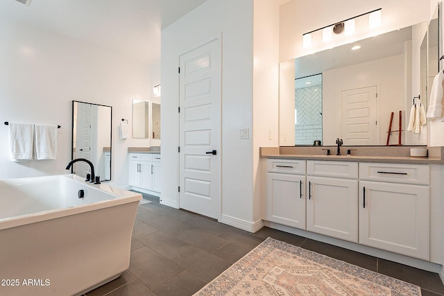 bathroom with a sink, a soaking tub, two vanities, and tile patterned flooring