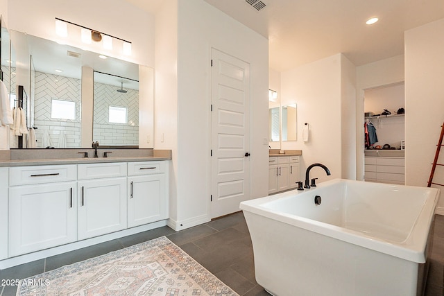 full bathroom featuring a freestanding tub, recessed lighting, two vanities, a sink, and tiled shower