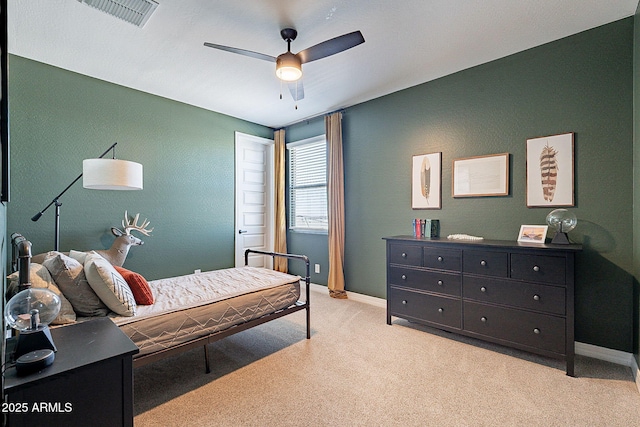 bedroom featuring light carpet, baseboards, visible vents, and a ceiling fan