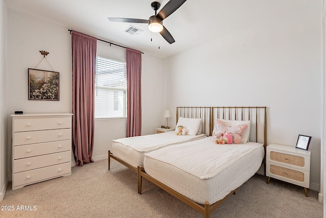 bedroom with light carpet, ceiling fan, visible vents, and baseboards