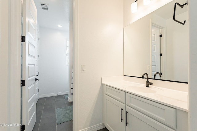 bathroom with visible vents, vanity, baseboards, and tile patterned floors