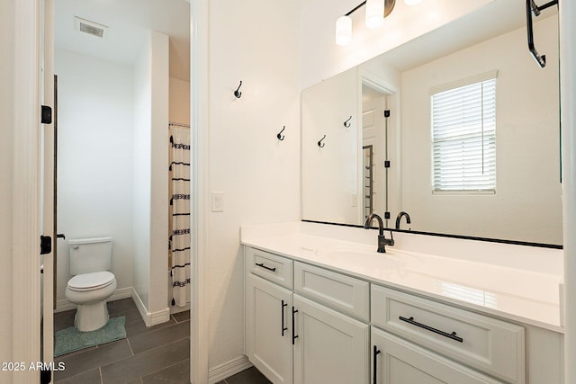 full bath with baseboards, visible vents, vanity, and toilet