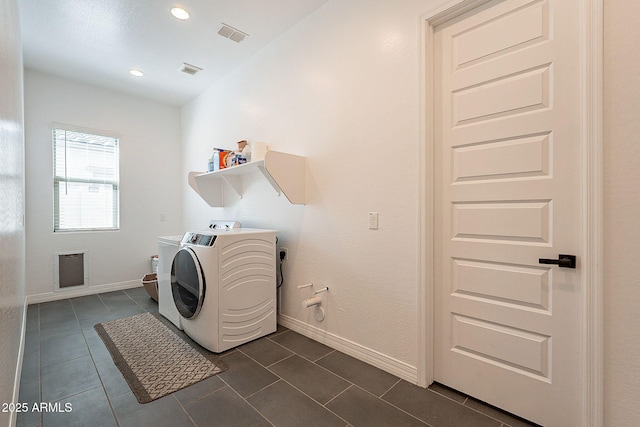 laundry area featuring laundry area, dark tile patterned floors, baseboards, and independent washer and dryer