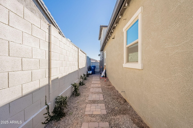 view of property exterior featuring concrete block siding, a fenced backyard, and stucco siding