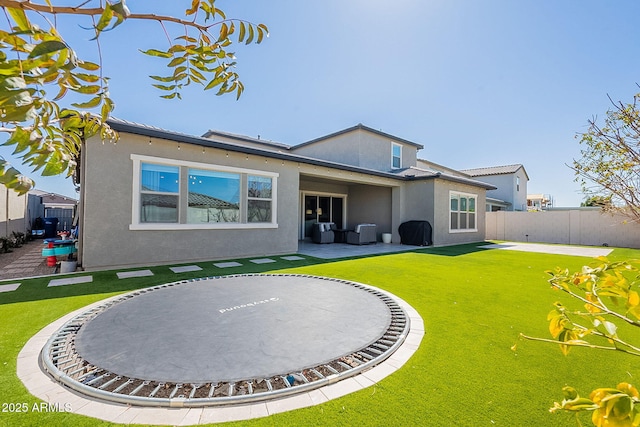 back of property featuring a yard, a patio, fence, and stucco siding