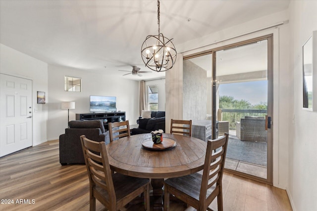 dining area featuring ceiling fan with notable chandelier and hardwood / wood-style flooring