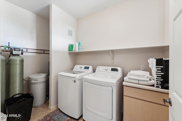 washroom with washer and clothes dryer and light tile patterned floors