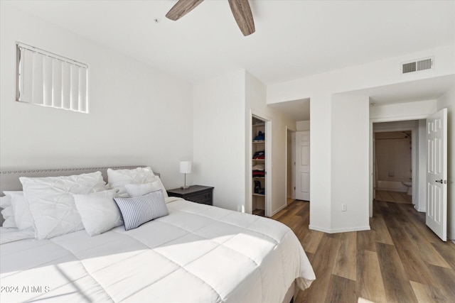 bedroom with hardwood / wood-style floors, ceiling fan, a walk in closet, and a closet