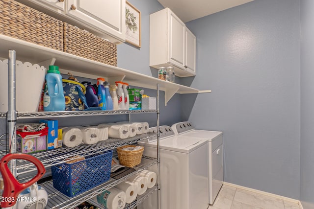 clothes washing area with light tile patterned floors, washing machine and dryer, and cabinets