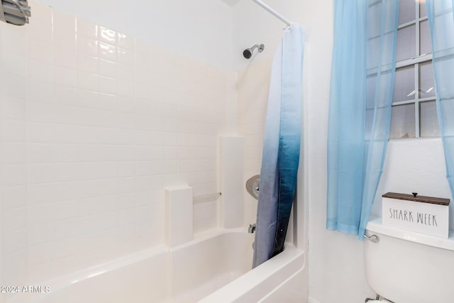 bathroom featuring shower / bath combination with curtain and toilet