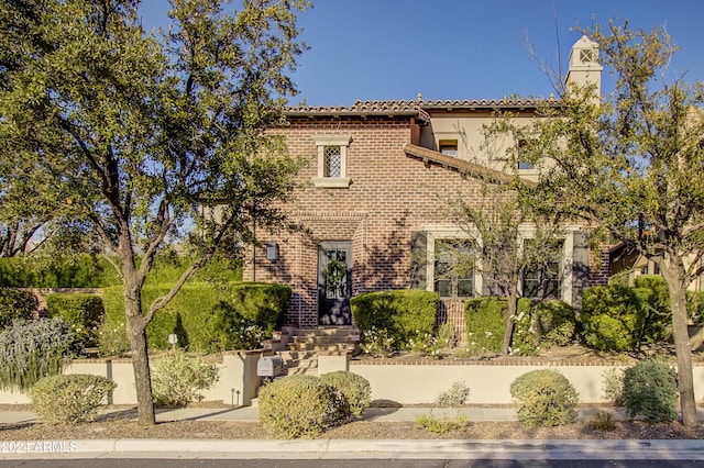 10191 E Diamond Rim Dr Unit 2122, Scottsdale, AZ 85255 - view of front of house with a chimney, brick siding, a tile roof, and stucco siding