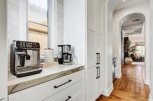 interior space with light stone counters, white cabinets, and light hardwood / wood-style floors