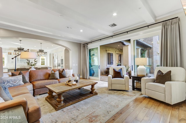 living room featuring beamed ceiling, a notable chandelier, and light wood-type flooring