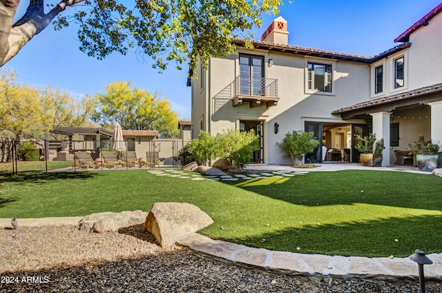 rear view of property featuring a lawn and a balcony