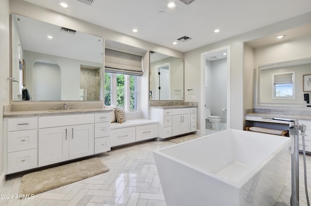 bathroom featuring a bath, vanity, and toilet