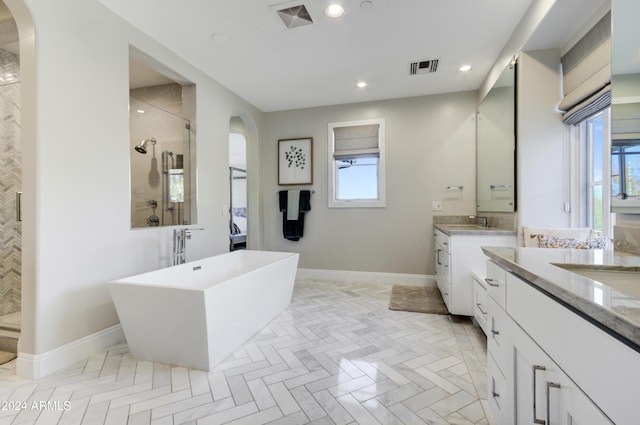 bathroom with vanity and shower with separate bathtub