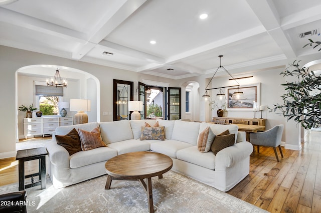 living room with coffered ceiling, crown molding, beamed ceiling, hardwood / wood-style floors, and a chandelier