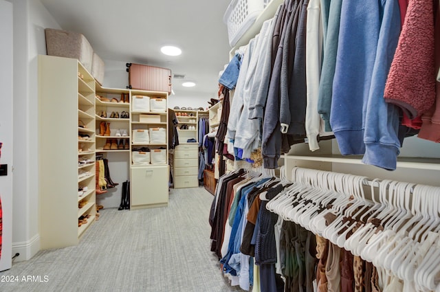 walk in closet featuring light carpet