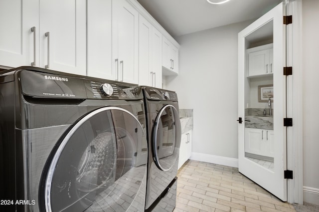 laundry room featuring cabinets and washer and clothes dryer