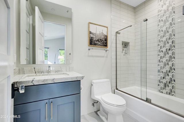 full bathroom featuring tile patterned flooring, vanity, toilet, and bath / shower combo with glass door