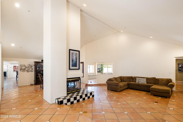 tiled living room with beam ceiling and high vaulted ceiling