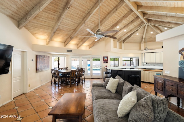 tiled living room with ceiling fan, beamed ceiling, wooden ceiling, and high vaulted ceiling