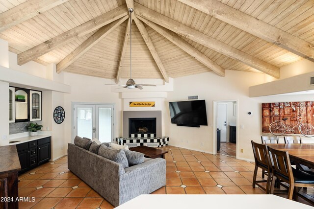 tiled living room featuring ceiling fan, french doors, wooden ceiling, beamed ceiling, and high vaulted ceiling