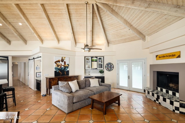 living room with wood ceiling, ceiling fan, beam ceiling, a barn door, and tile patterned flooring