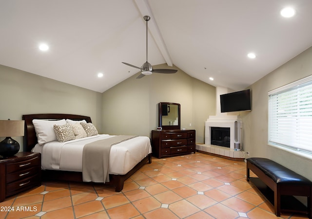 bedroom featuring a tile fireplace, light tile patterned floors, vaulted ceiling with beams, and ceiling fan