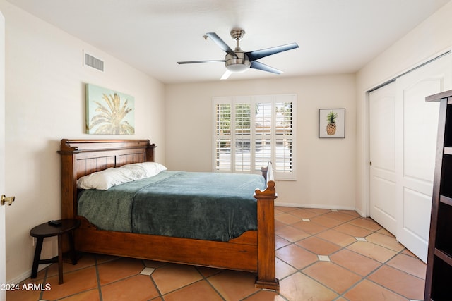 bedroom featuring ceiling fan, a closet, and light tile patterned floors