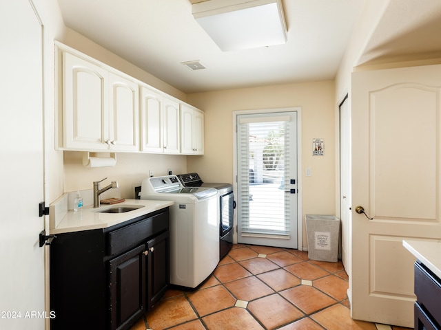 clothes washing area with cabinets, light tile patterned flooring, washer and clothes dryer, and sink