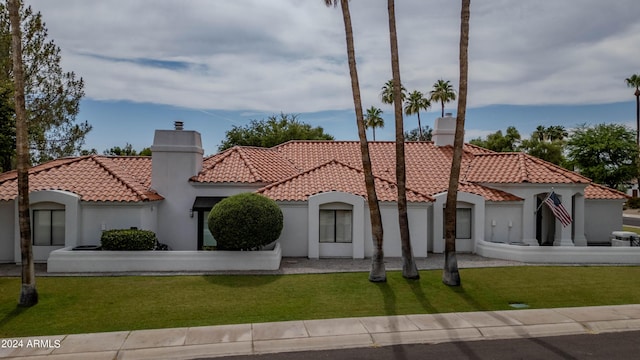 mediterranean / spanish-style home with a front lawn and a garage