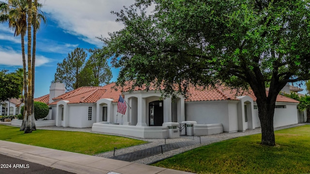 mediterranean / spanish-style home with a front yard