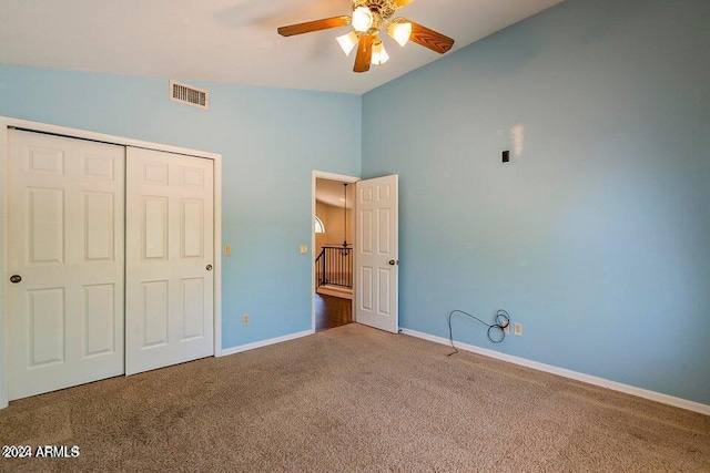 unfurnished bedroom with carpet, a closet, ceiling fan, and lofted ceiling