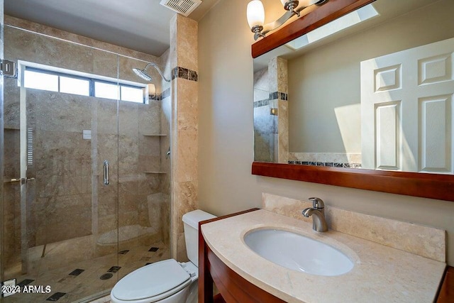 bathroom with vanity, toilet, and a shower with door