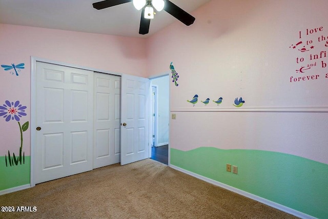 unfurnished bedroom featuring carpet flooring, ceiling fan, vaulted ceiling, and a closet