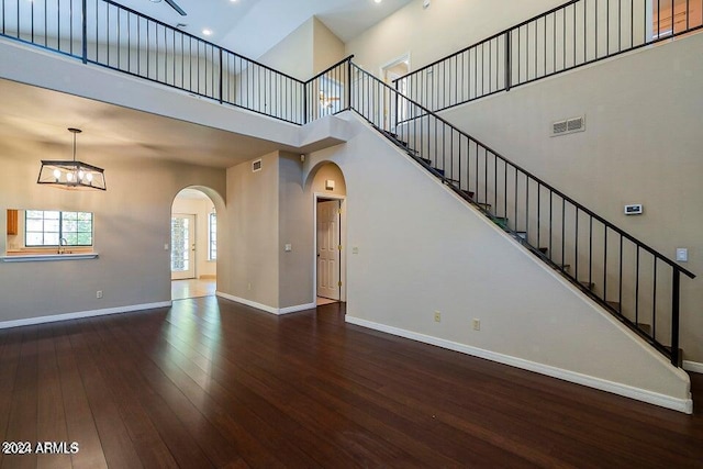 unfurnished living room with dark hardwood / wood-style flooring and a high ceiling