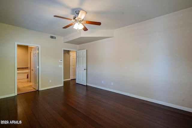 unfurnished bedroom featuring connected bathroom, dark hardwood / wood-style floors, and ceiling fan