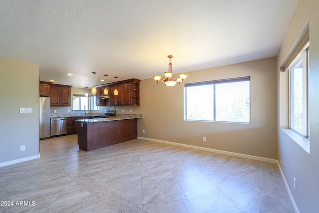 kitchen with stainless steel appliances, a textured ceiling, decorative light fixtures, a notable chandelier, and kitchen peninsula