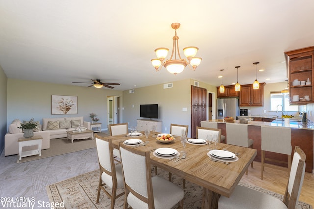 dining room with sink and ceiling fan with notable chandelier