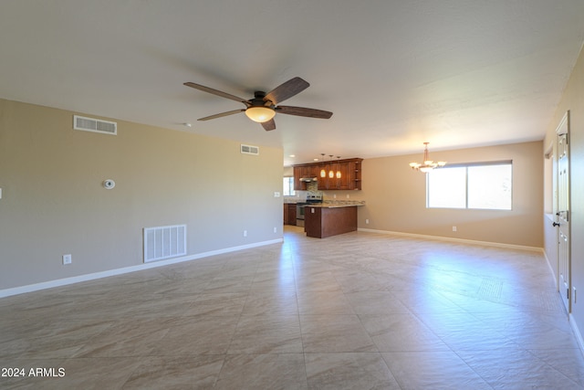 unfurnished living room with ceiling fan with notable chandelier