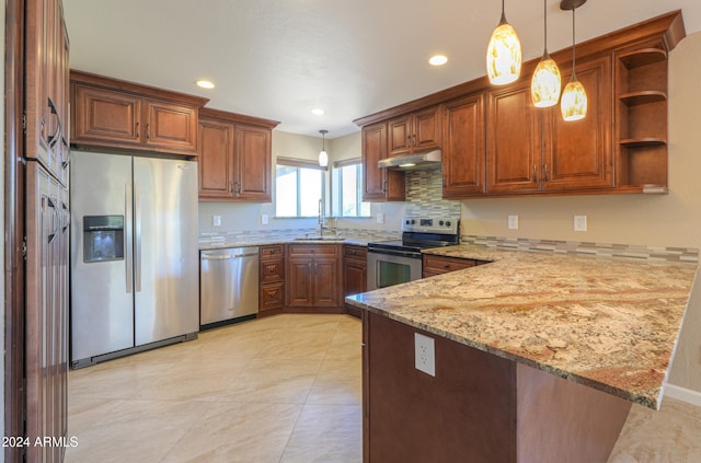 kitchen featuring stainless steel appliances, sink, kitchen peninsula, light stone countertops, and decorative light fixtures