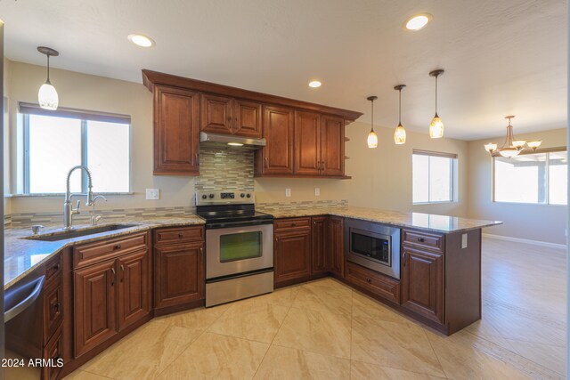 kitchen with sink, kitchen peninsula, appliances with stainless steel finishes, hanging light fixtures, and a wealth of natural light