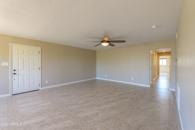 spare room with ceiling fan and a textured ceiling