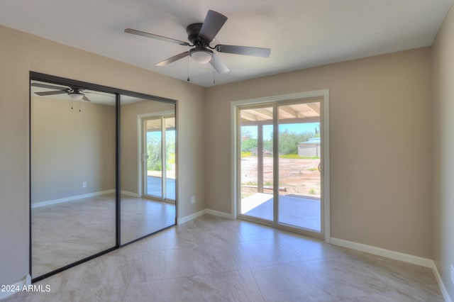 unfurnished bedroom with access to outside, multiple windows, and ceiling fan