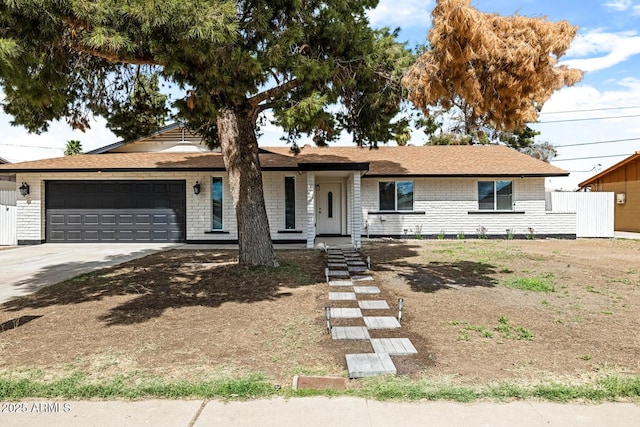 single story home with concrete driveway, brick siding, and an attached garage